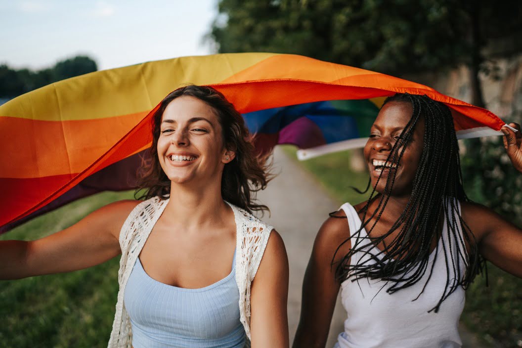 Two women holding a rainbow flag.