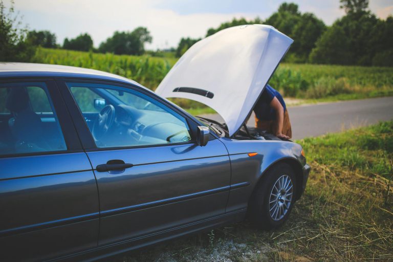 A person looking at the engine of their car.